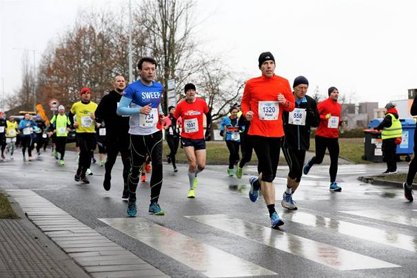 A group of people walking on a sidewalk

Description automatically generated